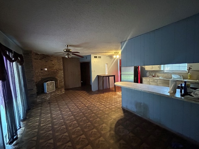 living area with visible vents, a textured ceiling, a ceiling fan, and dark floors