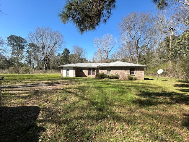 back of property with brick siding and a yard