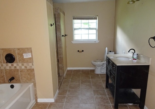 bathroom with tile patterned floors, vanity, toilet, and a tub to relax in