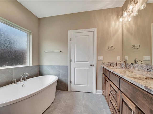 bathroom featuring a tub, vanity, and tile walls