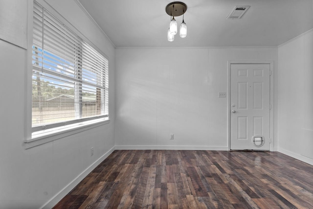 spare room with crown molding, dark wood-style flooring, baseboards, and visible vents