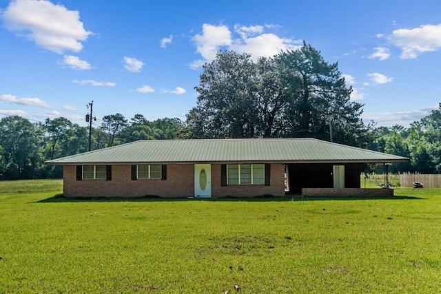 ranch-style home featuring metal roof and a front yard