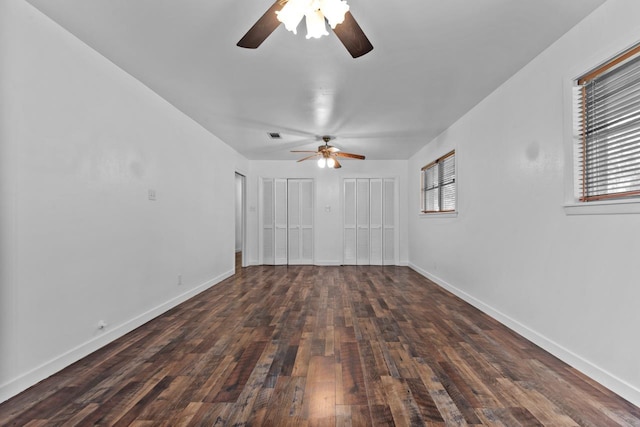 empty room featuring wood finished floors, baseboards, and a ceiling fan
