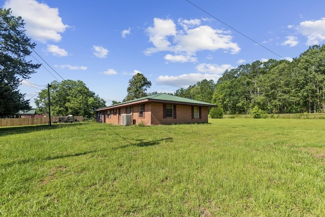 view of property exterior with fence and a lawn
