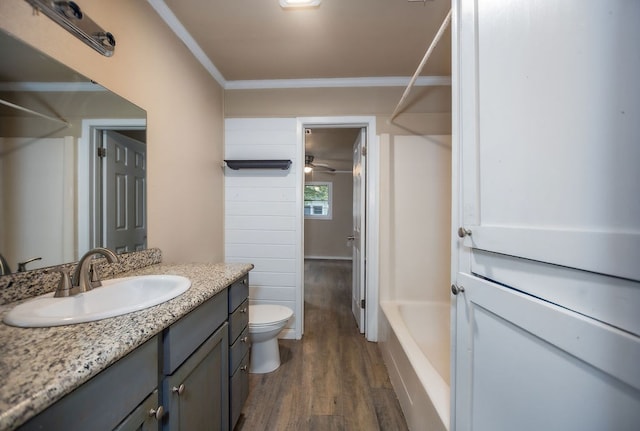 full bathroom with hardwood / wood-style floors, vanity, shower / washtub combination, toilet, and ornamental molding