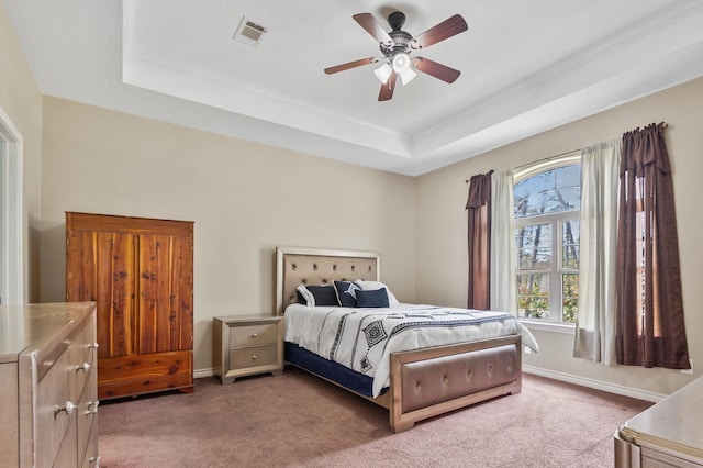 bedroom featuring carpet floors, a tray ceiling, and ceiling fan