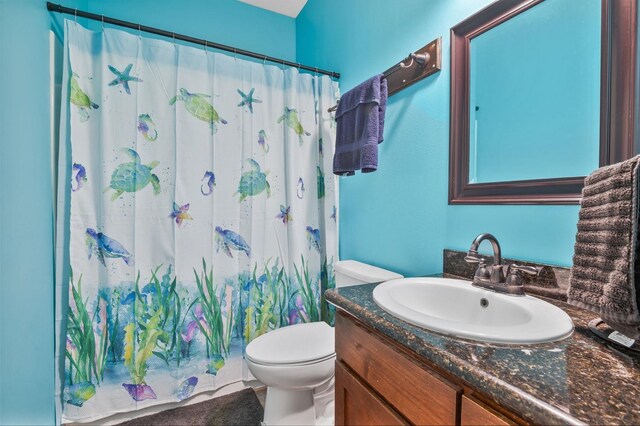 bathroom with vanity, a shower with shower curtain, and toilet