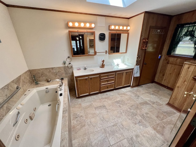 bathroom with a washtub, crown molding, vanity, and a skylight