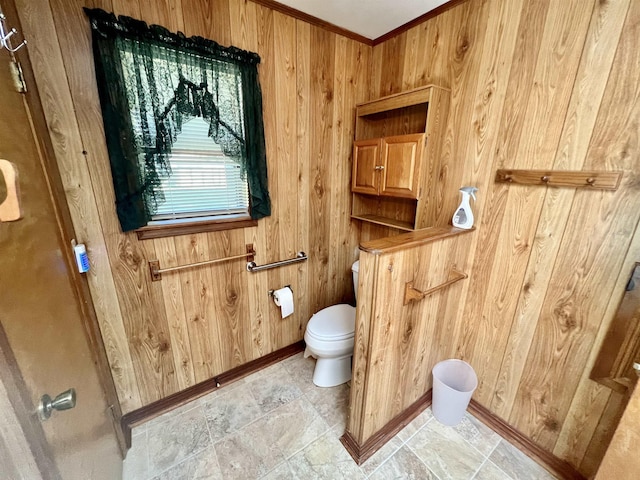 bathroom featuring wooden walls, ornamental molding, and toilet