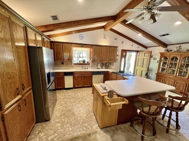 kitchen with a breakfast bar, kitchen peninsula, sink, vaulted ceiling with beams, and stainless steel fridge with ice dispenser