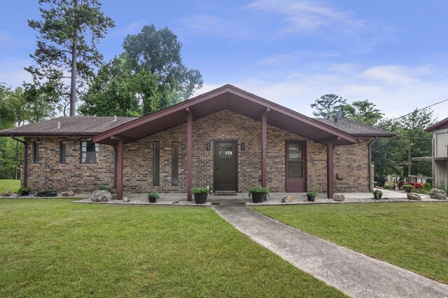 217 County Road 223, Brookeland, TX 75931 - view of front of house featuring a front yard, brick siding, and roof with shingles