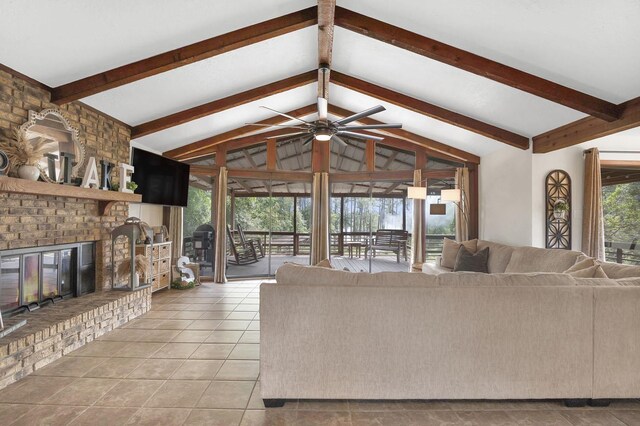 living room with a fireplace, light tile patterned floors, lofted ceiling with beams, and ceiling fan