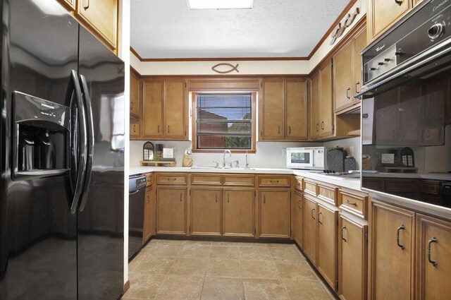 kitchen with sink, black appliances, a textured ceiling, and ornamental molding