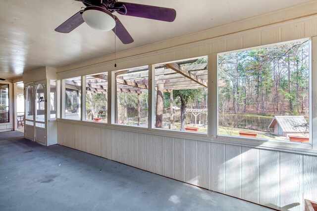 unfurnished sunroom featuring a wealth of natural light and ceiling fan