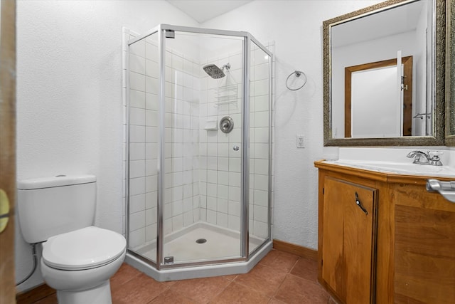 bathroom featuring tile patterned floors, vanity, toilet, and a shower with shower door