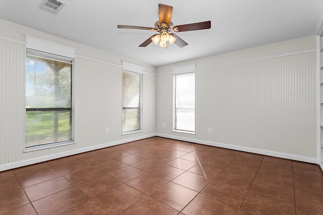 empty room featuring dark tile patterned flooring and ceiling fan