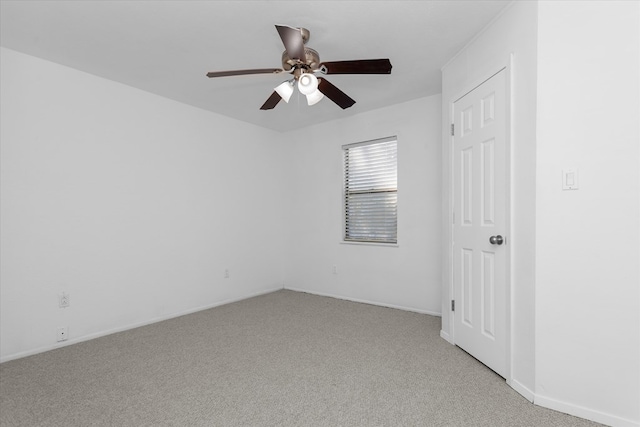 spare room with ceiling fan and light colored carpet