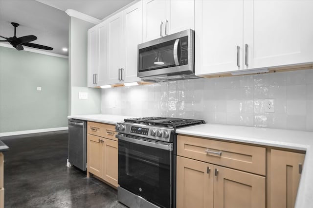 kitchen featuring ceiling fan, stainless steel appliances, decorative backsplash, white cabinets, and ornamental molding