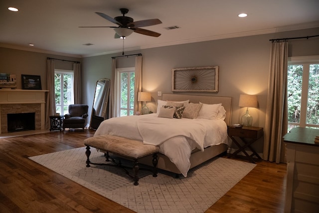 bedroom featuring ceiling fan, ornamental molding, dark hardwood / wood-style floors, and multiple windows