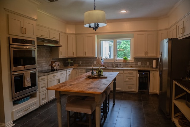 kitchen with decorative light fixtures, white cabinetry, stainless steel appliances, wine cooler, and sink