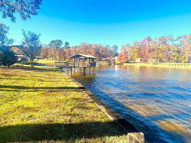 dock area featuring a lawn and a water view
