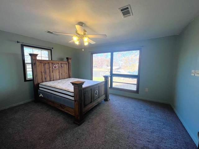 bedroom featuring baseboards, visible vents, dark carpet, and ceiling fan