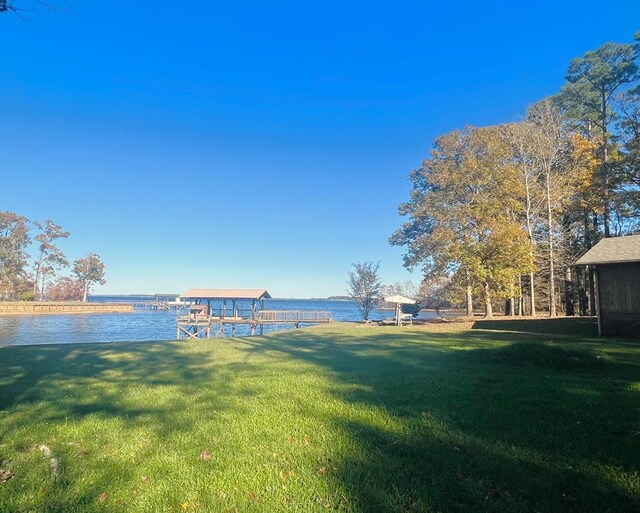 view of yard featuring a water view and a boat dock
