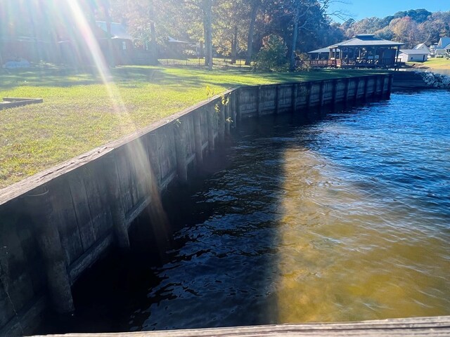 dock area with a yard and a water view