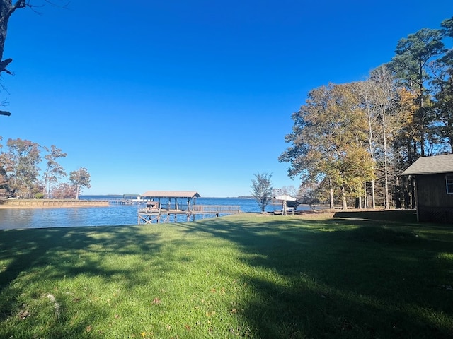 view of yard featuring a water view and a dock