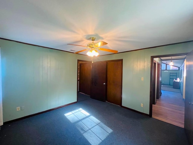 unfurnished bedroom with baseboards, visible vents, carpet floors, ceiling fan, and crown molding