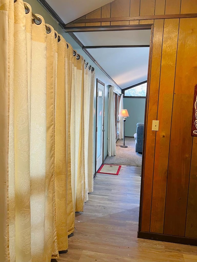 corridor with lofted ceiling and wood finished floors