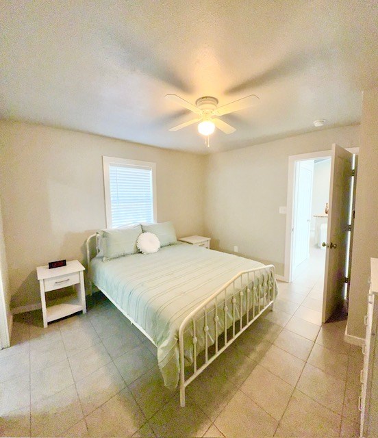 bedroom with ceiling fan and a textured ceiling