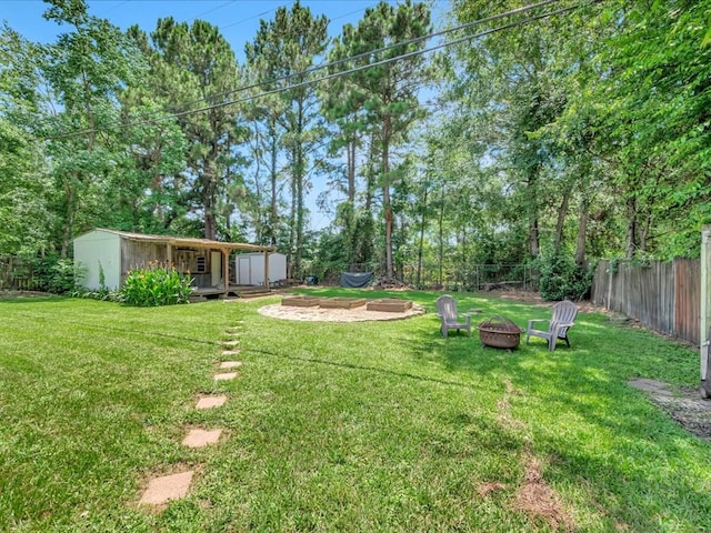 1318 Sue Dr, Lufkin, TX 75901 - fenced backyard with a fire pit and an outdoor structure