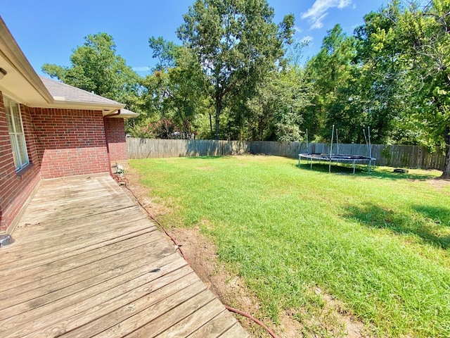 view of yard with a deck and a trampoline