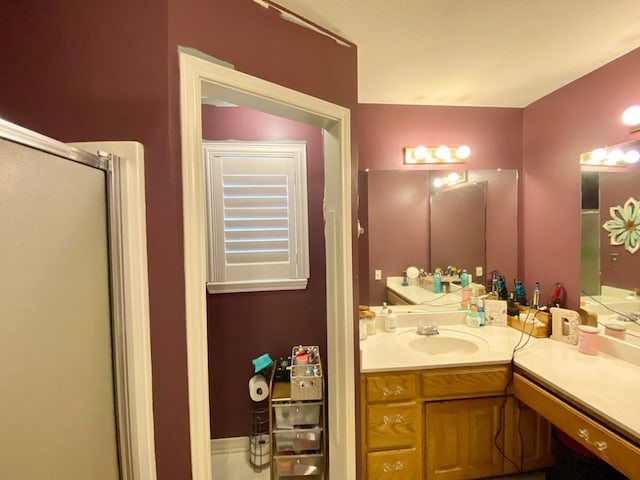 bathroom with vanity and a shower with door