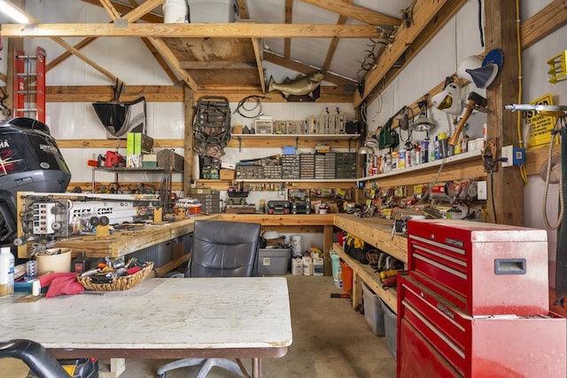misc room featuring a workshop area, vaulted ceiling, and concrete flooring