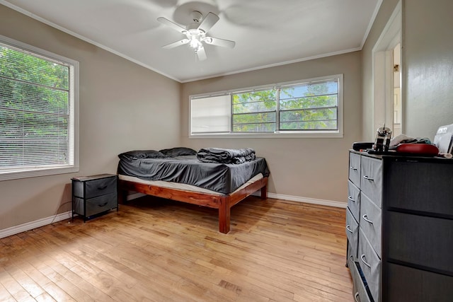 bedroom featuring ceiling fan, crown molding, and light hardwood / wood-style floors