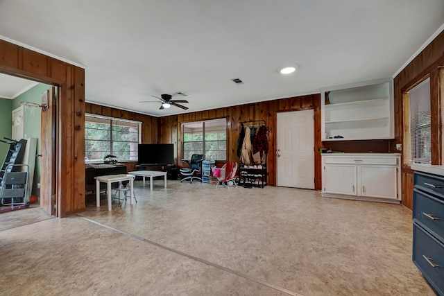 unfurnished office featuring ornamental molding, ceiling fan, and wooden walls