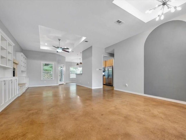 unfurnished living room with ceiling fan with notable chandelier and a raised ceiling