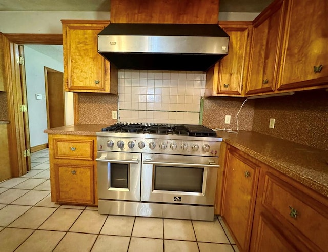 179 County Road 4587, Spurger, TX 77660 - kitchen featuring range with two ovens, range hood, and brown cabinets