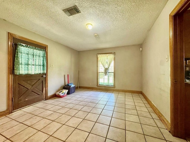 179 County Road 4587, Spurger, TX 77660 - unfurnished room featuring light tile patterned floors, a textured ceiling, and baseboards