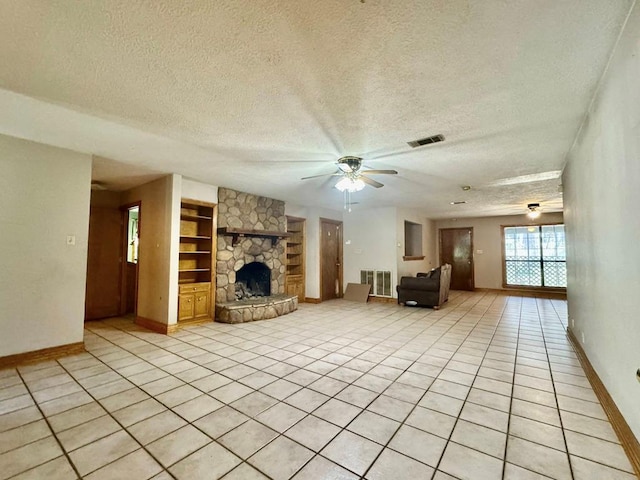 179 County Road 4587, Spurger, TX 77660 - unfurnished living room featuring a ceiling fan, a textured ceiling, light tile patterned floors, and baseboards