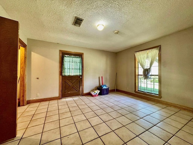 179 County Road 4587, Spurger, TX 77660 - spare room featuring light tile patterned floors, baseboards, and a textured ceiling
