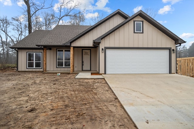 view of front of home featuring driveway, an attached garage, roof with shingles, and board and batten siding