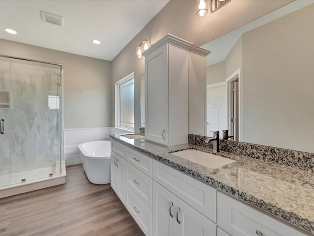 128 Stoney Rdg, Lufkin, TX 75904 - bathroom with vanity, a marble finish shower, a freestanding bath, wood finished floors, and a wainscoted wall
