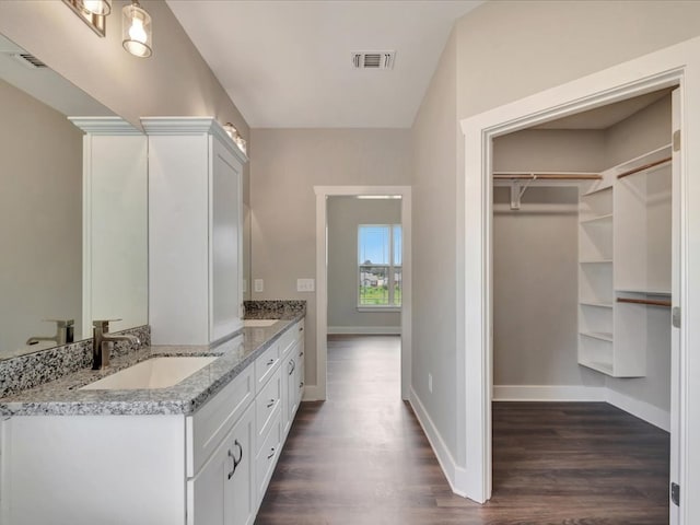 128 Stoney Rdg, Lufkin, TX 75904 - bathroom featuring double vanity, wood finished floors, and a spacious closet