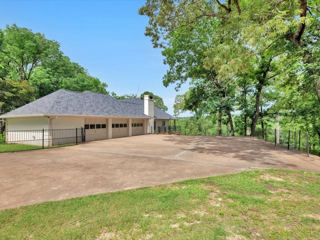 5078 US Highway 21, Nacogdoches, TX 75964 - view of side of property featuring an attached garage, driveway, a chimney, and a shingled roof