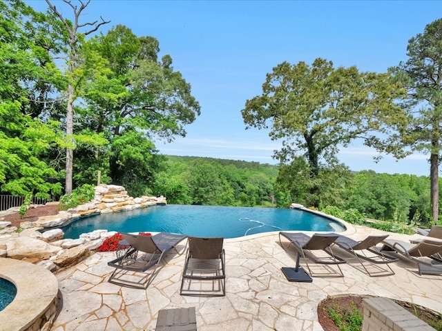 5078 US Highway 21, Nacogdoches, TX 75964 - view of swimming pool with a patio area, an infinity pool, and a view of trees