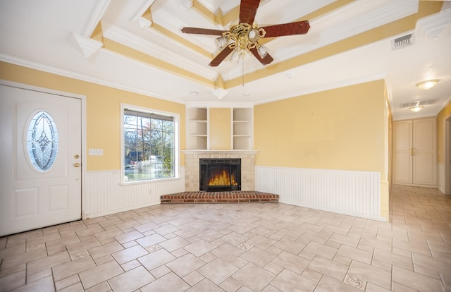 unfurnished living room featuring built in shelves, ceiling fan, and crown molding