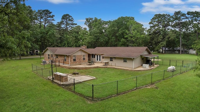 back of house with a fenced backyard, a chimney, a yard, and a patio area